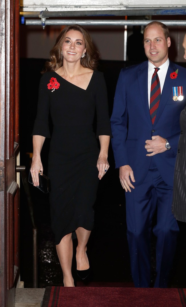 Masih dalam rangkaian acara yang sama, Kate tampil cantik dengan gaun hitam midi berkerah asimetris yang elegan. Gaunnya disempurnakan clutch dan heels berwarna serupa. Foto: Dok. Getty Images