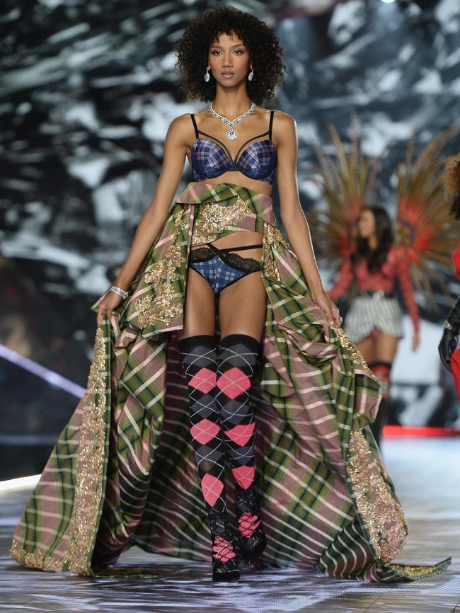 Lingerie kotak-kotak bernuansa kehijauan menemani penampilan model Aiden Curtis. Gayanya disempurnakan dengan kaus kaki tinggi bermotif senada. (Foto: Getty Images)