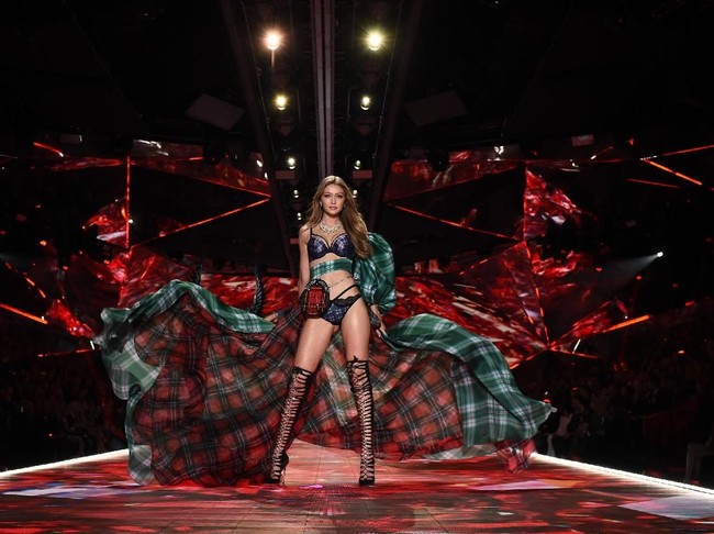 Berikutnya Gigi Hadid yang tampil dengan lingerie kotak-kotak dalam kombinasi warna merah, hijau, dan biru. Tidak ketinggalan tas kecil khas Skotlandia, sporran, yang melilit di pinggang. Sementara itu, kaki jenjangnya berbungkus heels gladiator yang semakin mempertegas keseksiannya. (Foto: Getty Images)