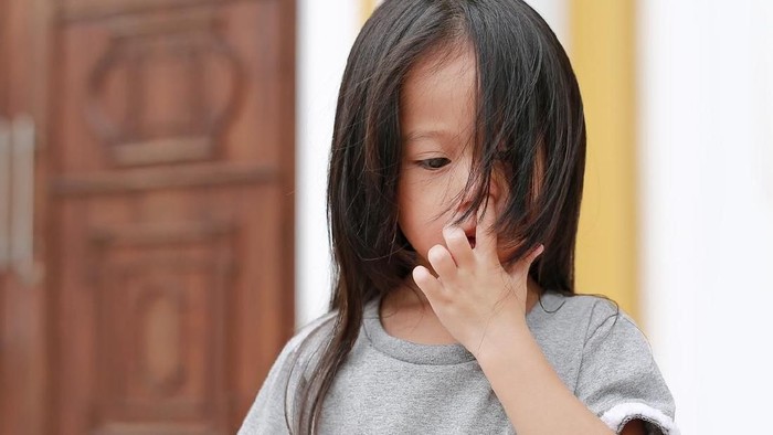 Ngupil Long hair little child girl pick her nose.
