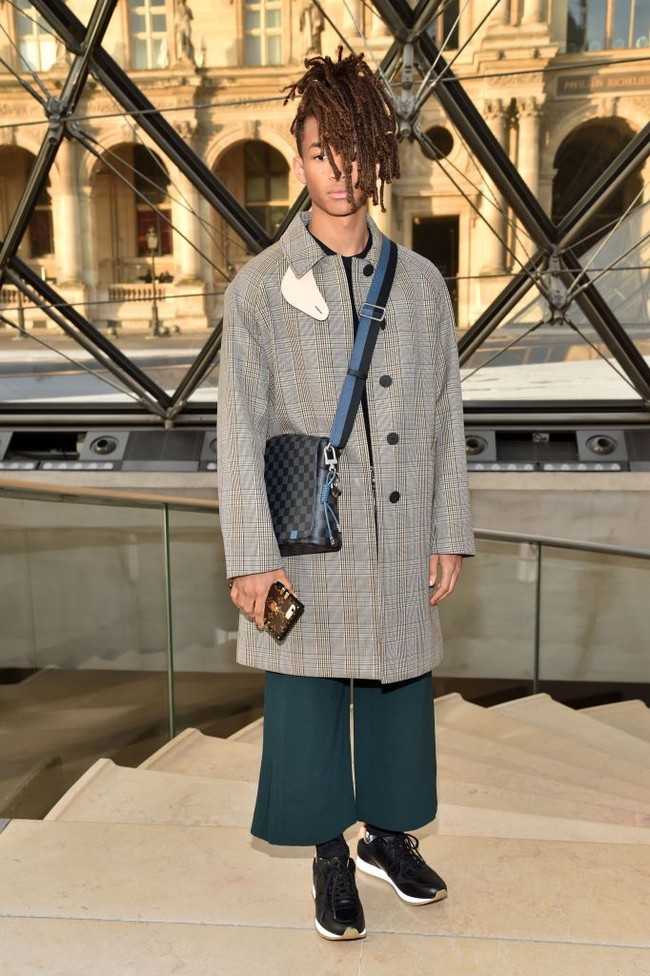 Ini adalah salah satu penampilan Jaden Smith saat datang menonton fashion show Louis Vuitton. Pria yang pertamakali muncul di layar lebar bersama ayahnya melalui film The Pursuit of Happyness itu tampak memakai coat panjang dan celana berpotongan lebar. Foto: Getty Images
