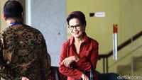 Miranda tampak mengenakan pakaian warna merah dan membawa tas berwarna hitam. Ia tak henti melemparkan senyum saat tiba di gedung KPK.