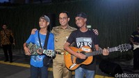 Anies juga sempat foto bersama dengan musisi jalanan yang ditemuinya.