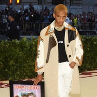 Menghadiri Met Gala 2018, Jaden Smith juga tetap dengan merek busana favoritnya, Louis Vuitton. Kali ini dia memadukan trench coat Louis Vuitton dengan kaus dari label busananya sendiri MSFTS. Dan salah satu penampilannya yang menarik atensi hari itu adalah, Jaden membawa plakat penghargaan untuk singlenya Icon. Aksesori yang unik untuk dibawa kemanapun di Met Gala. Foto: Getty Images