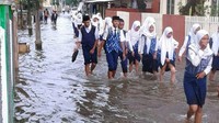 Siswa sekolah dengan menembus banjir. Mereka tetap semangat belajar.