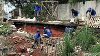 Puluhan petugas gabungan dari Satgas Bina Marga, Sudin SDA dan petugas Penanganan Prasarana dan Sarana Umum (PPSU) dikerahkan untuk mempercepat proses pengerjaan perbaikan Jalan Tiu, RT 03/04, Kelurahan Setu, Cipayung, Jakarta Timur yang longsor setelah hujan deras, Minggu (11/11) kemarin.
