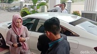 Charly dan Regina turun dari mobil Civic putih.