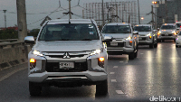 Iring-iringan Mitsubishi New Triton melintasi jalan raya di Bangkok, Thailand.