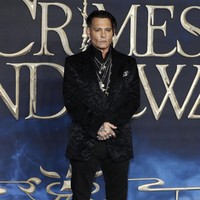 Johnny Depp memamerkan penampilan eksentrik dengan jas velvet dan tumpukan aksesori perak yang trendi. Foto: Getty Images
