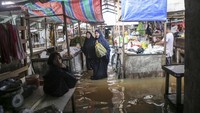 Sejumlah pedagang beraktifitas di lapak dagangnya yang terendam banjir dikawasan Sekip Bendung, Palembang, Sumatera Selatan, Selasa (13/11/2018). Antara Foto/Nova Wahyudi.