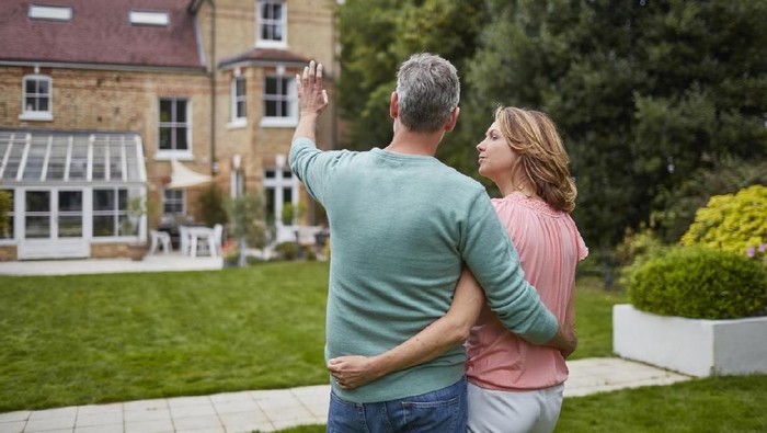 A couple in their 50s moves in to their new home, unpacking boxes and enjoying the time together.  Could also depict moving out of a home.