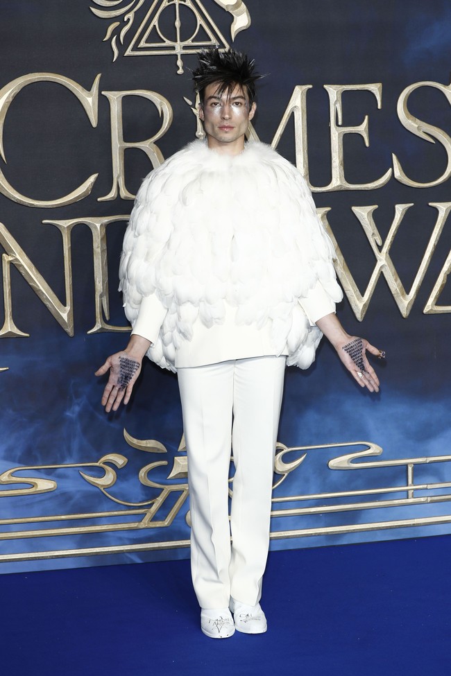 Ezra Miller memastikan perhatian tertuju hanya padanya. Ornamen bulu pada setelan putih hingga pulasan perak di wajah sukses membuatnya tampil mencuri atensi. Foto: Getty Images