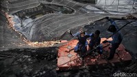 Tiga orang berada di permukaan Kali Item menggunakan pelampung kotak untuk memotong waring.