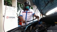 Petugas mengisi BBG ke sebuah taksi.