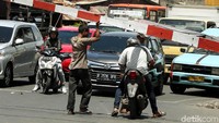 Dua penumpangnya kemduain turun, salah satunya membuka palang pintu kereta api di jalan Letjen Suprapto, Bungur, Senen, Jakarta Pusat, Kamis (15/11/2018).