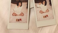 Ngemil di atas tempat tidur, Cella tetap tampil cantik dengan pose imutnya di kamera polaroid. Foto: Instagram @cindercella