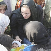 Angelina Jolie tidak memilih turban atau jilbab lain yang mungkin terlihat lebih fancy. Ia memilih pashmina sederhana berbahan kashmir dengan pemakaian yang simpel tanpa peniti. Foto: Getty Images