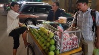 Dahnil terlihat santai berbincang dengan tukang rujak gerobak di malam hari. Kira-kira buah apa ya yang dibeli Dahnil? Foto: Instagram dahnil_anzar_simanjuntak