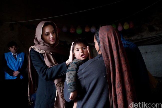 Tahun 2011, Angelina Jolie juga pernah mengunjungi Kabul, Afganistan. Mengunjungi salah satu keluarga muslim korban perang, ia tampak cantik mengenakan pashmina berwarna cokelat. Foto: Getty Images