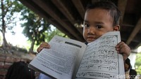 Seorang anak menunjukan buku iqra miliknya.