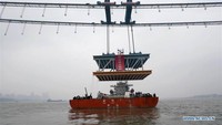 Sebuah balok baja seberat 1.000 ton tampak sedang diangkat untuk dipasang di lokasi konstruksi Jembatan Yangsigang di sepanjang Sungai Yangtze di Wuhan, ibukota Provinsi Hubei di China tengah. Istimewa/Xinhuanet.