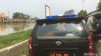 Haris dibawa ke Kalimalang dengan mobil warna hitam.  Haris yang mengenakan baju tahanan warna oranye dengan tangan diborgol itu dijaga polisi berpakaian preman. Di deretan kedua bangku, 2 polisi membawa senjata api siaga mengamankan Haris. Foto: (Rolan-detikcom)