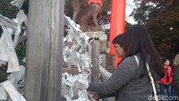 Kemudian kamu bisa mengambil omikuji atau selembaran yang sesuai dengan angka yang keluar sebelumnya. Kalau mendapatkan angka sial biasanya mereka mengikatkan kertas ini pada tali besi ini (Aisyah Kamalia/detikTravel)