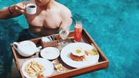 Pemeran sinetron Dear Nathan The Series ini punya penampilan yang keren, ini posenya saat sarapan di dalam kolam renang dengan nasi goreng, kentang goreng, hingga secangkir kopi hangat. Foto: Instagram @zikridaulay1