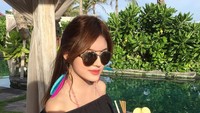 Segelas minuman dengan garnish apel jadi teman santai Tanaya. Ia terlihat duduk di pinggir kolam. Kacamata hitam membuat tampilan Tanaya makin kece. Foto: instagram @tanayalyssia