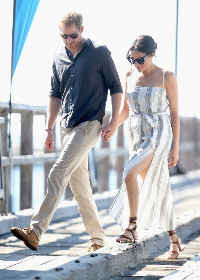 Meghan Markle tampil kasual berbalut summer dress dari brand asal Amerika, Reformation saat mengunjungi  Fraser Island, Australia, Oktober 2018. Gaun bermotif garis itu sebenarnya sedikit berisiko untuk dikenakan seorang anggota kerajaan, karena memiliki potongan paha tinggi yang hanya ditutup dengan kancing besar. Foto: Dok. Getty Images
