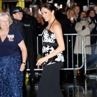Meghan lalu menyempurnakan gayanya dengan clutch hitam berkilauan, berikut pointed heels hitam yang menopang kedua kakinya. Foto: Chris Jackson/Getty Images