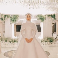 Untuk hijabnya, Nada memakai hijab segi empat dipadukan dengan veil. Veil tersebut bertabur payet yang senada dengan busana yang ia pakai. Ia memilih warna putih untuk momen sakralnya itu.  Foto: ThePhotoMoto