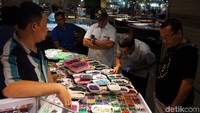 Beberapa orang pecinta batu akik sedang mengamati batu yang akan dibelinya.