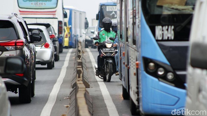 Polisi menilang pengendara sepeda motor yang nekat melintas di Flyover Pesing, Jakarta Barat, Rabu (21/11/2018).