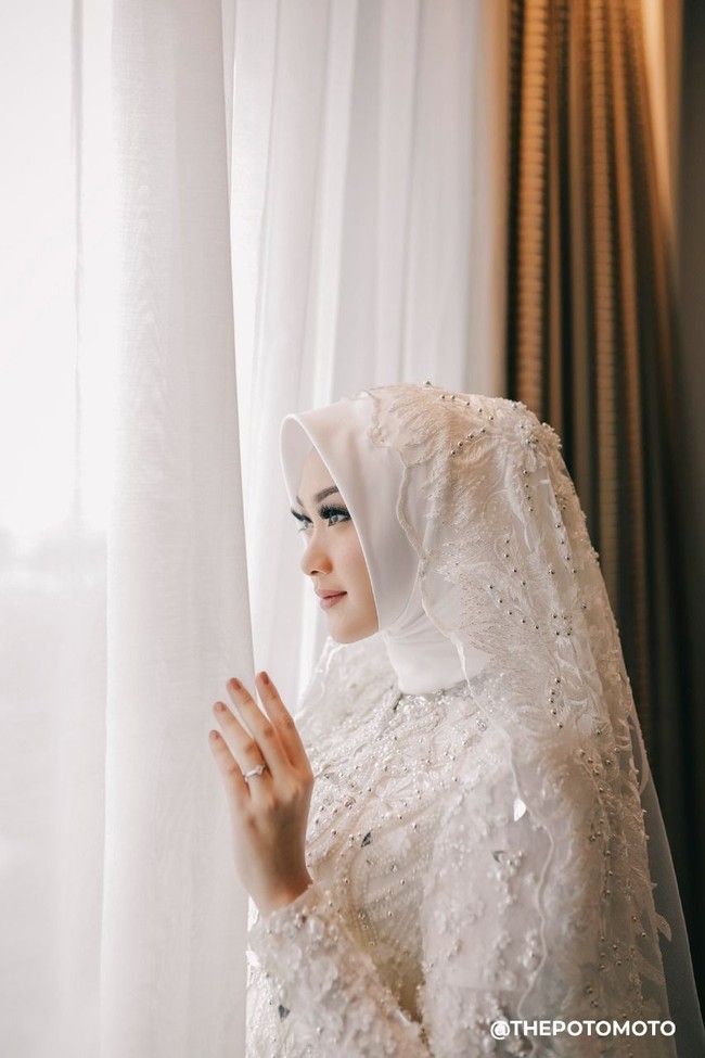 Riasan saat akad nikah terlihat natural tapi memiliki garis tegas yang membuat tampilan Nada lebih glowing. Riasan itu merupakan karya MUA berhijab cantik Vivi Thalib. Foto: ThePhotoMoto