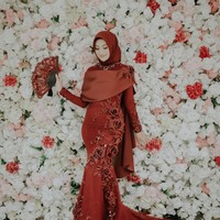 Di penghujung acara, Nada memakai busana karya Ayu Dyah Andari. Busana berwarna merah marun itu memiliki potongan mermaid dengan detail payet dan bordir yang kompleks. Nada juga memakai hijab berwarna merah marun, sehingga tampilannya malam itu terlihat glamor tapi tetap manis. Foto: Aspherica