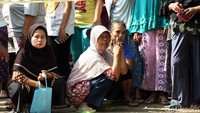 Warga terus berdatangan untuk menonton rekonstruksi. Mereka menonton dengan berdiri dan duduk-duduk di depan garis polisi.
