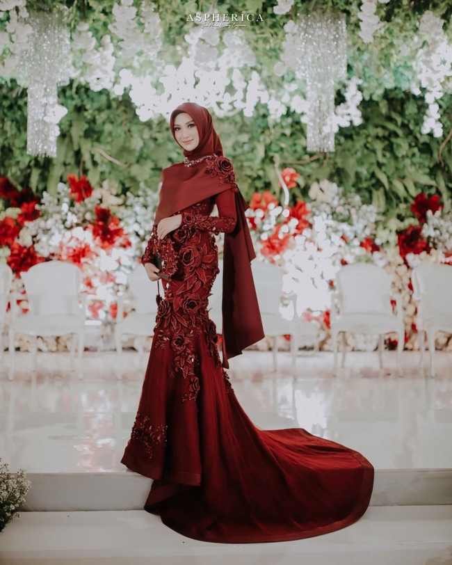 Nada juga memilih hijab segi empat sederhana dipadukan dengan veil dan mahkota untuk resepsi. Untuk riasan wajahnya, Nada memercayakan gaya natural ala Marlene Hariman, MUA hits yang juga merias penyanyi Raisa saat menikah. Foto: Aspherica