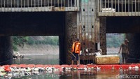 Sejumlah petugas Sudin SDA tampak sedang membersihkan sampah yang hanyut di sekitar Kali Ciliwung.