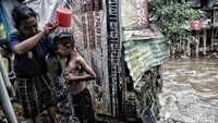 Seorang anak mandi di depan toilet umum di bantaran Kali Ciliwung, Jakarta.
