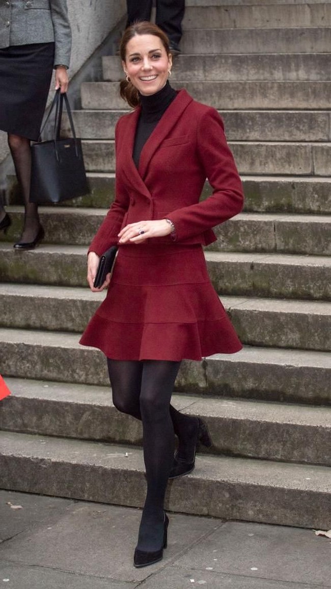 Busana tersebut terdiri dari blazer model double-breasted serta rok flare berwarna merah wine yang dipadukan dengan dalaman turtleneck, stocking serta heels serba hitam. Ia juga menyumparnakan gayanya dengan clutch hitam. (Foto: Getty Images)