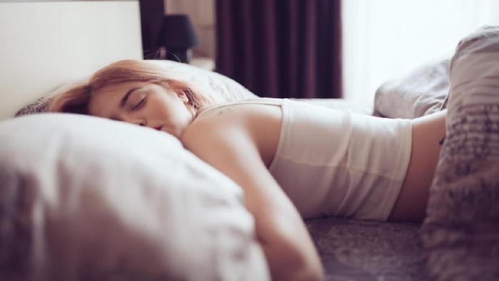 tidur ngiler ngorok bangun pagi Young woman sleeping in bed. Space for copy.