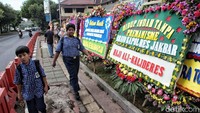 Dua siswa SMP melintas di depan jejeran karangan di depan Polres Jakarta Barat.