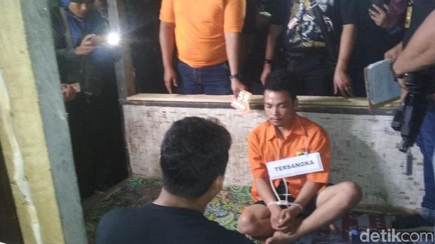 Tersangka pembunuhan satu keluarga di Bekasi, Haris Simamora saat rekonstruksi di Garut, Kamis (22/11/2018)