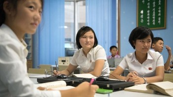 Pemandangan lazim di ruang kelas sekolah, ketika para murid mendengarkan gurunya. Selain memakai buku dan pulpen, lirik pula ke tengah meja para murid. (Foto: Carl Court/Getty Images)
