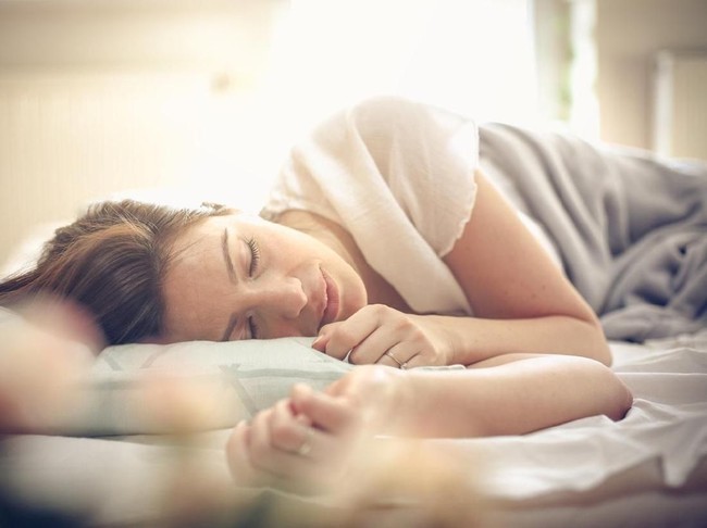 Young woman sleeping in bed. Space for copy.