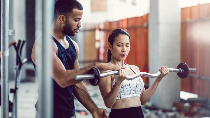 personal trainer Personal Trainer Coaching a Female Athlete While Lifting Weights