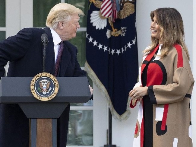 Melania Trump memakai coat yang mencuri atensi ketika perayaan Hari Thanksgiving di Gedung Putih, Selasa (20/11/2018) lalu. First Lady Amerika ini memilih Christian Dior sebagai padanannya hari itu, sementara suaminya, Donald Trump memakai setelan jas hitam seperti biasa. Foto: dok. AFP