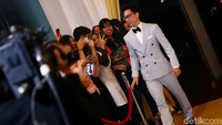 Atlet bulutangkis itu terlihat elegan mengenakan seteklan tuxedo berwarna abu-abu.