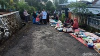 Warga akan menggelar makanan di sepanjang jalan menuju ke pemakaman. Setiap warga membawa jenis makanan yang berbeda, sehingga satu sama lain saling berbagi mencoba satu per satu makanan yang ada. (Dadang/detikTravel)